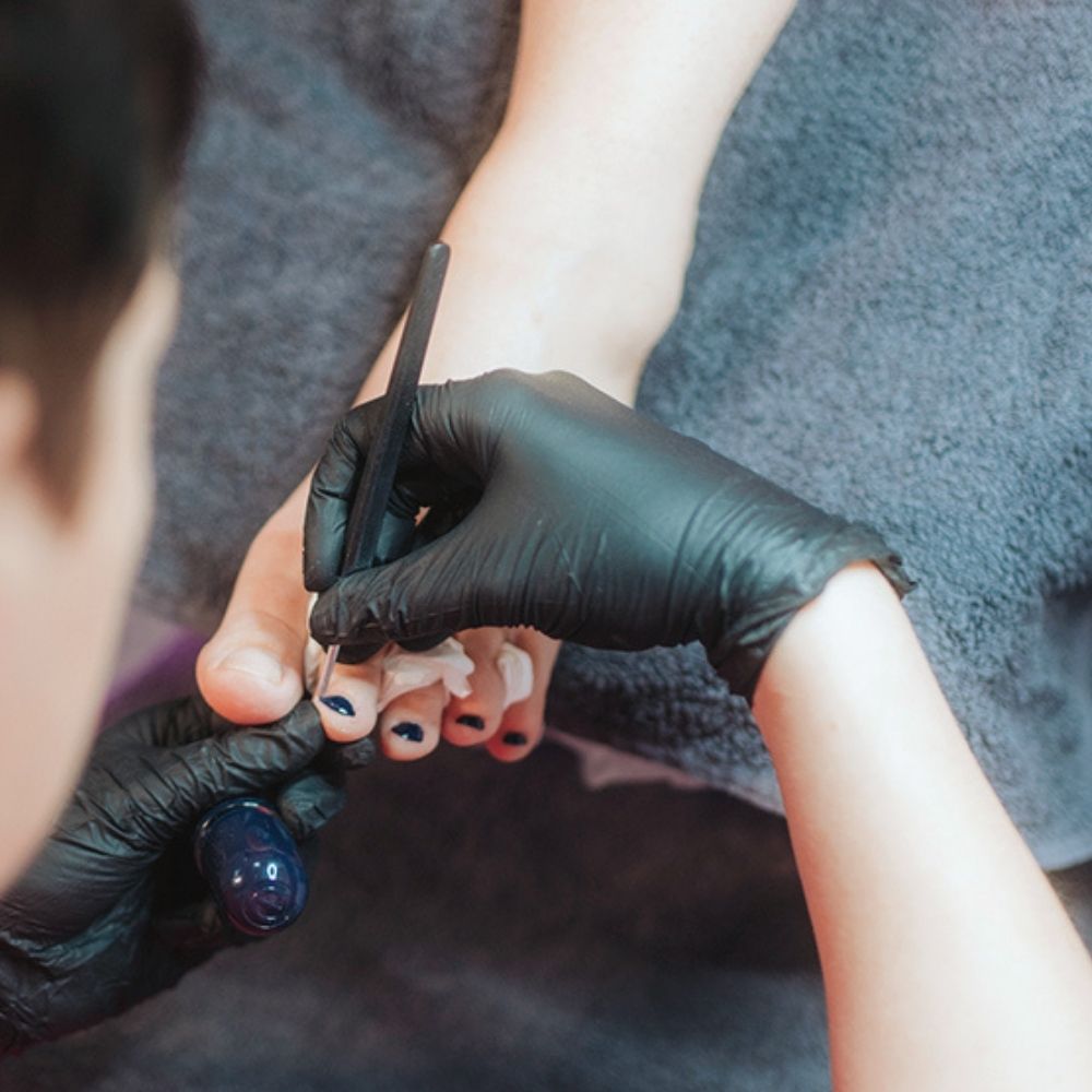 Kosmetikerin führt professionelle Fußpflege-Behandlung im Studio in Wiener Neustadt durch